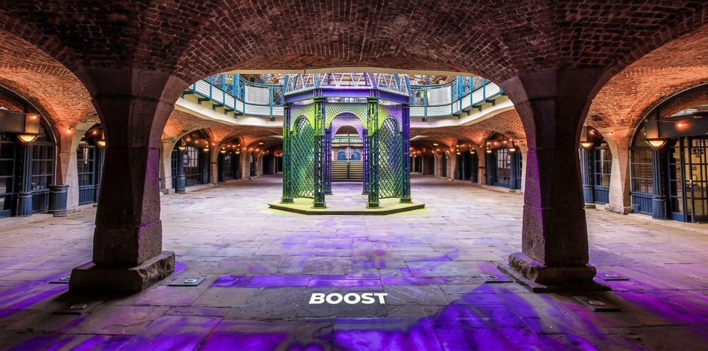 Vaulted hall lit in purple and lime with BOOST projection
